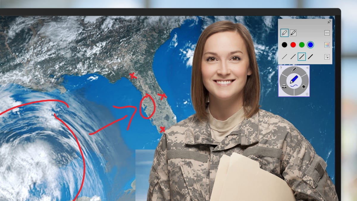 A smiling woman in military uniform standing in front of a SMART interactive display.