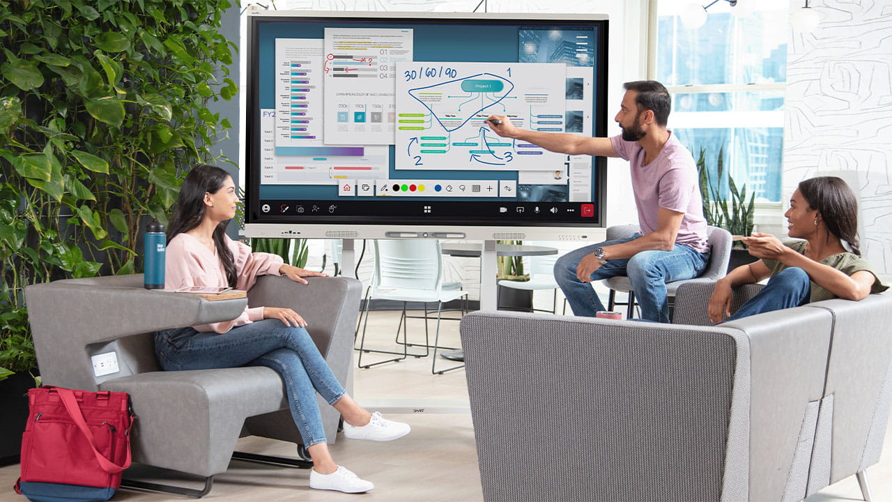 University students collaborating with a SMART Board in a modern study space.