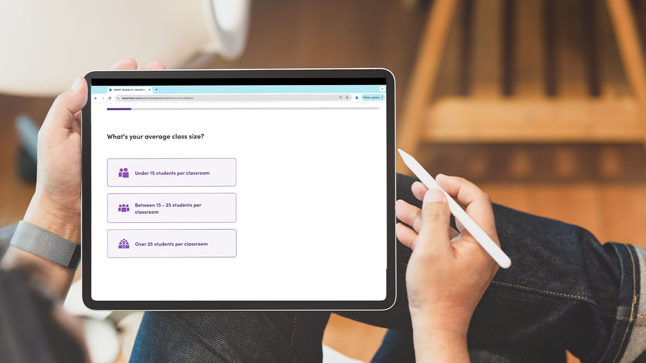 A person holding a tablet displaying the SMART Board selector tool with options for average class size.